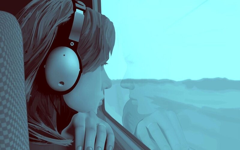 person with headphones looking out window