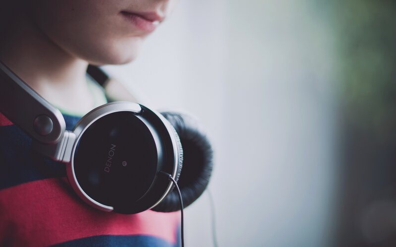person with headphones on shoulder