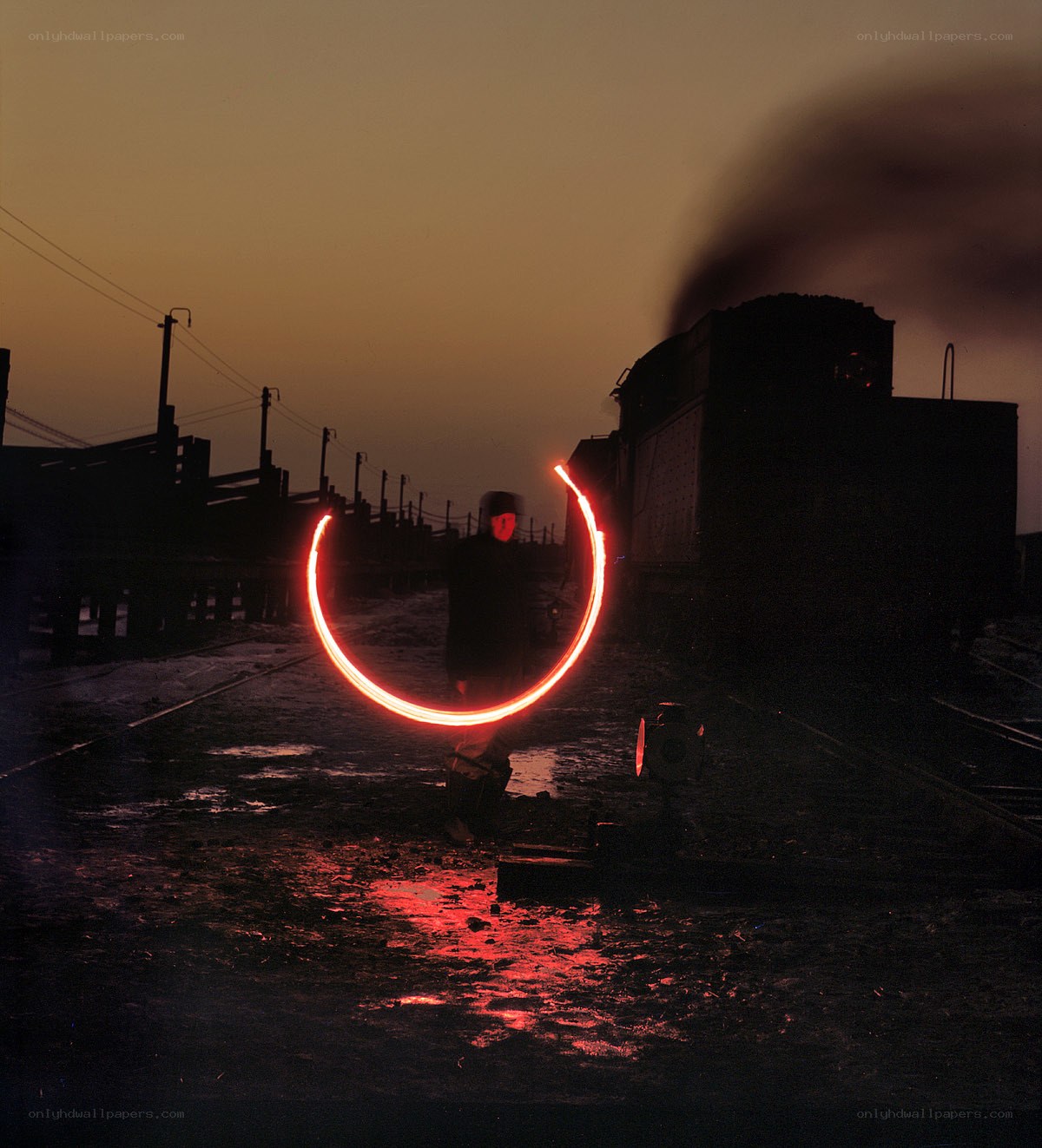 Person with light circle at train yard