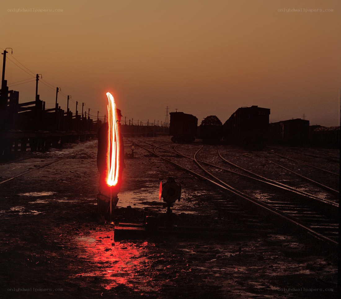 Person with light trail at train yard