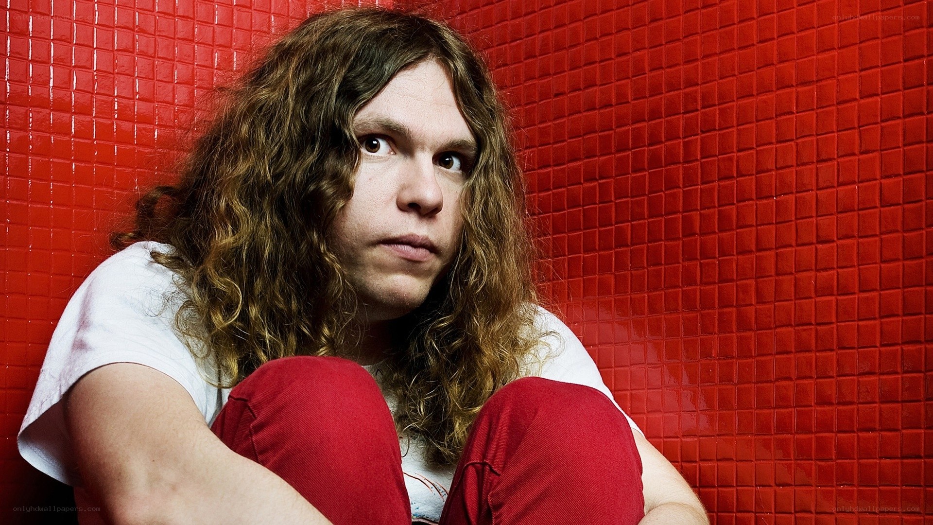 person with long hair against red wall