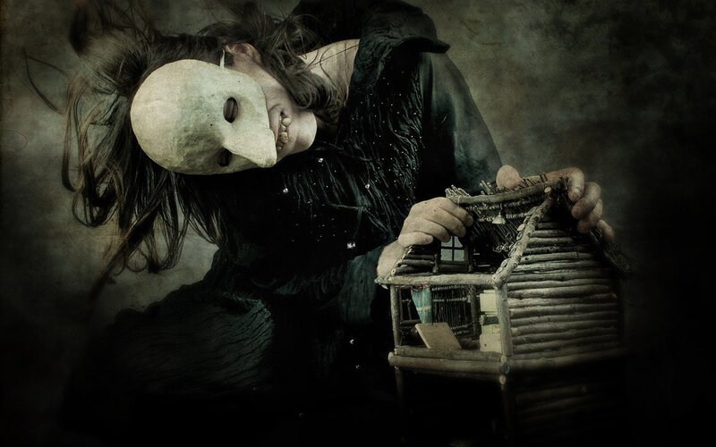 person with mask holding dollhouse