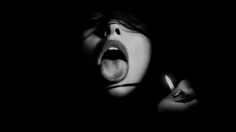 person with open mouth holding lighter