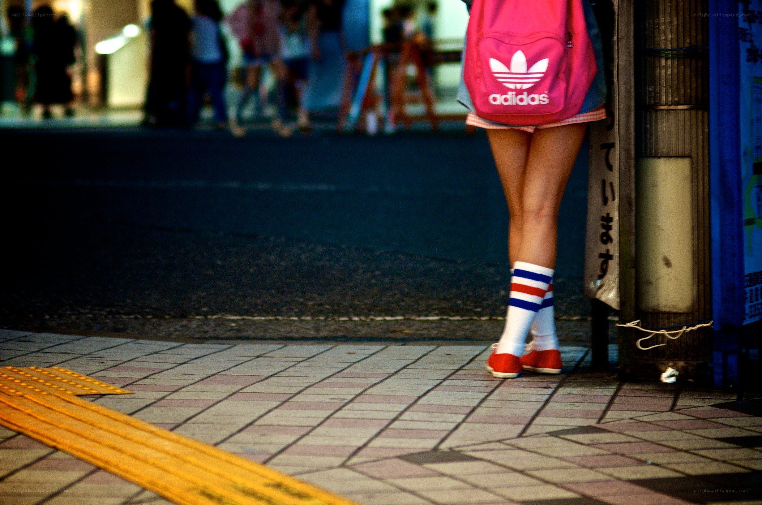 person with pink backpack on sidewalk