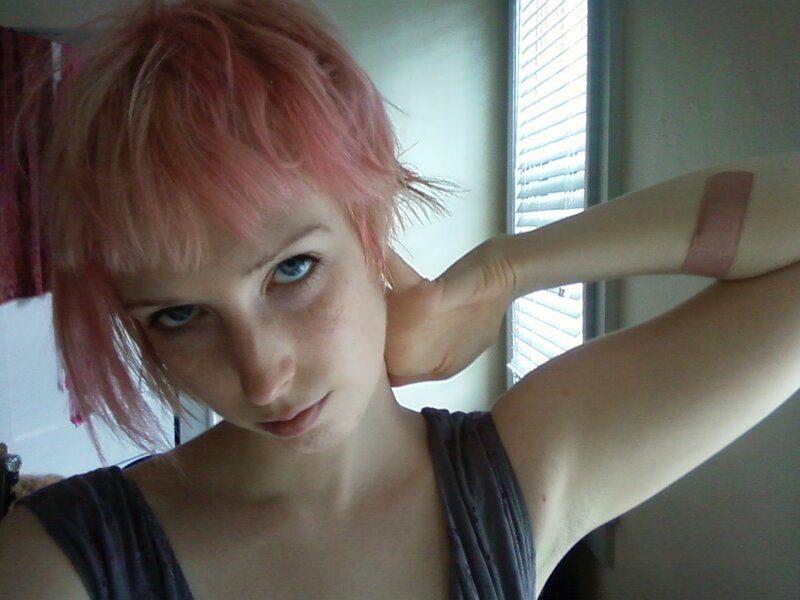 person with pink hair and bandage