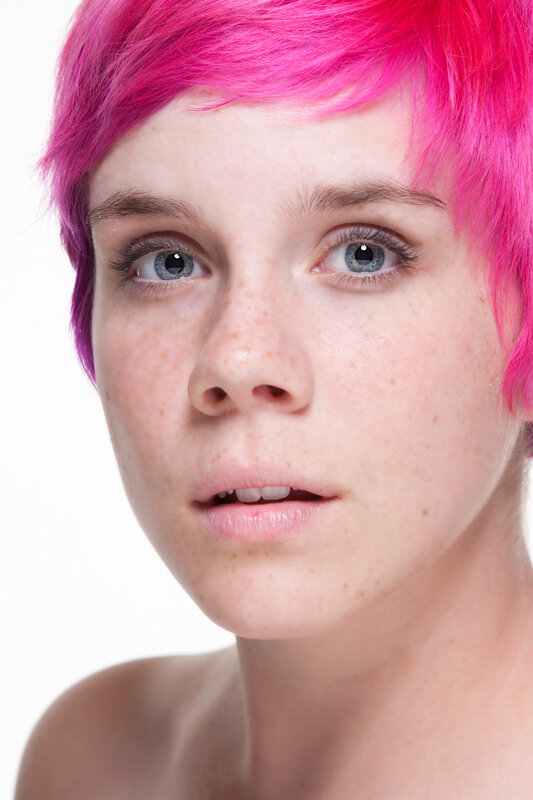 person with pink hair and freckles