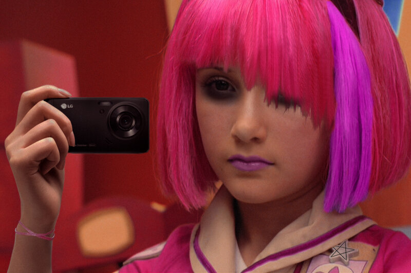 person with pink hair holding camera