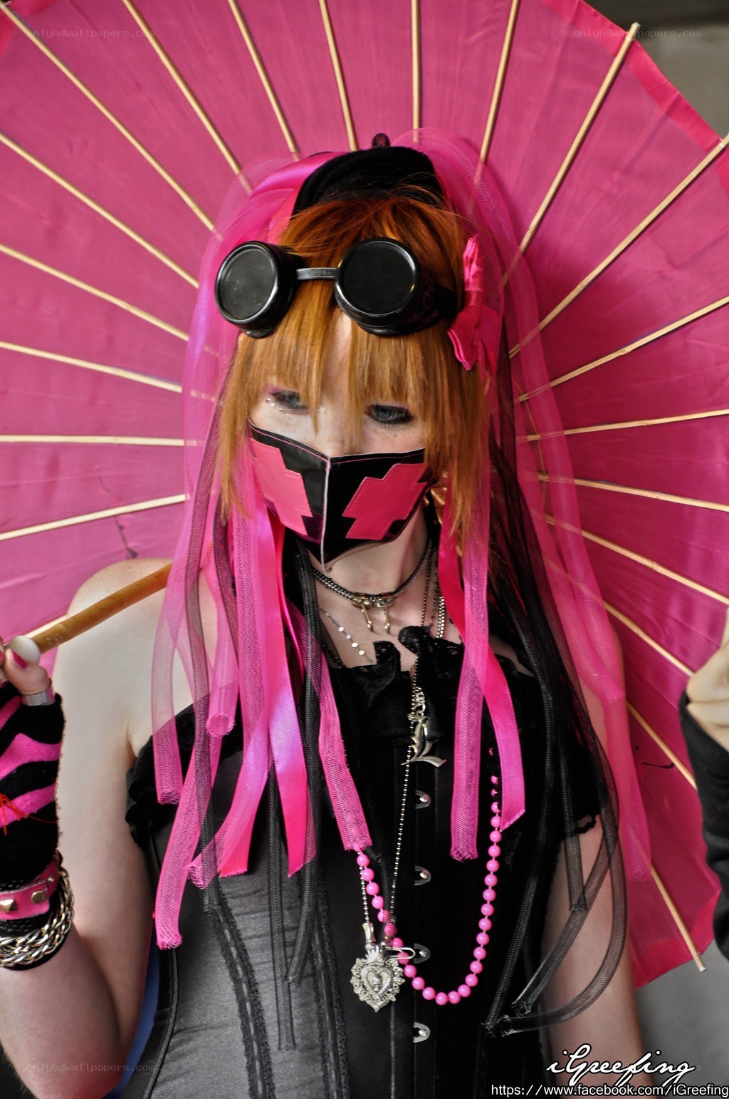person with pink umbrella and goggles