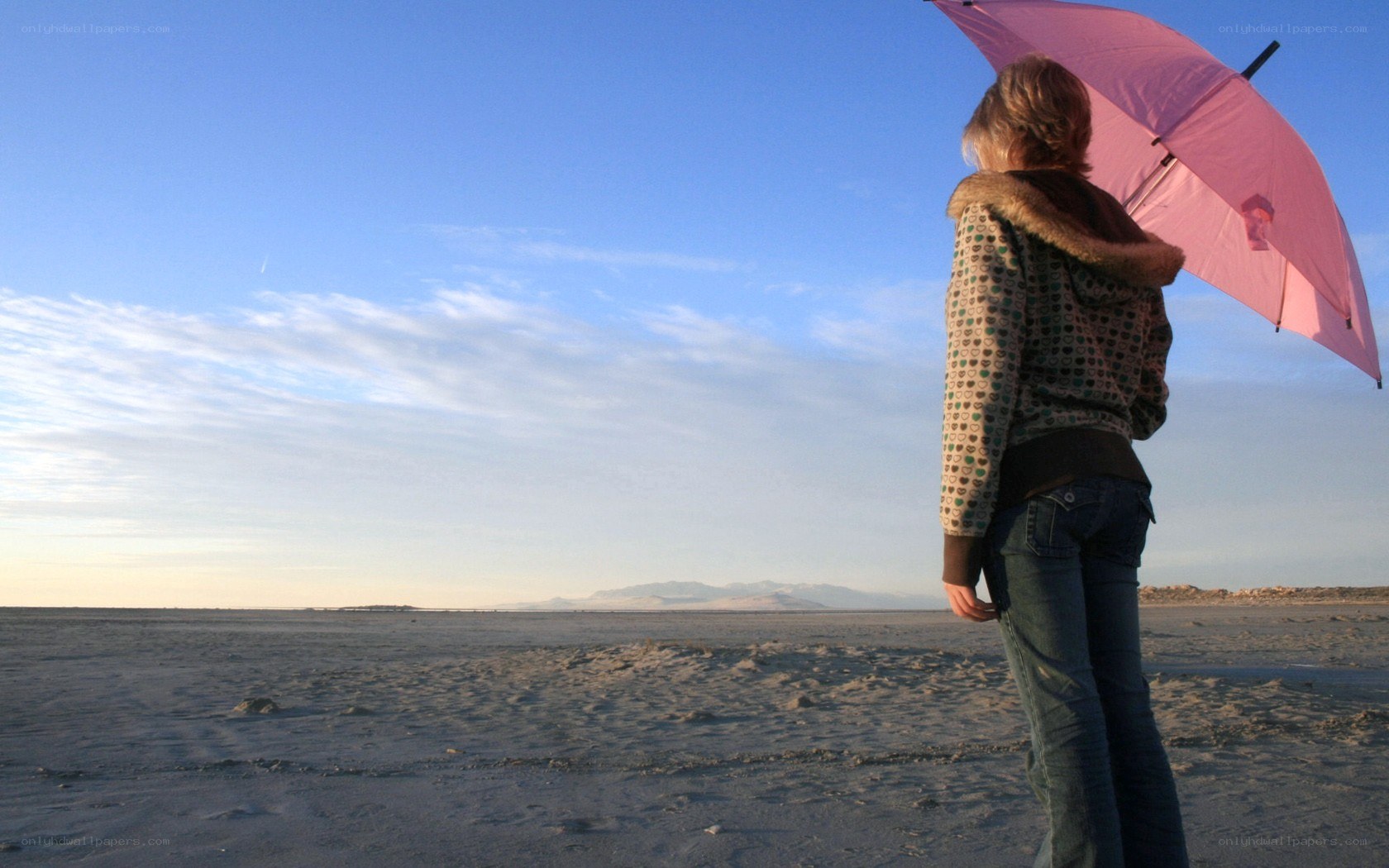 person with pink umbrella on beach