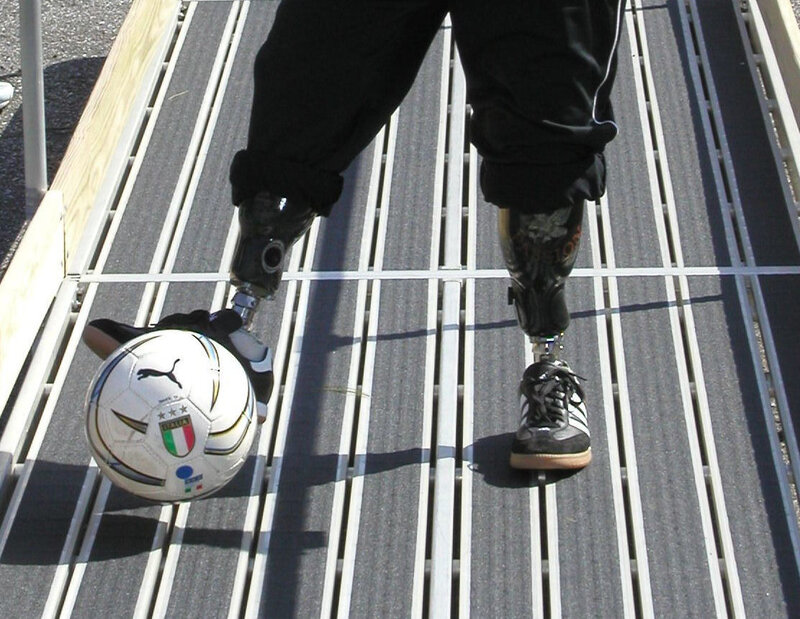 person with prosthetic legs playing soccer
