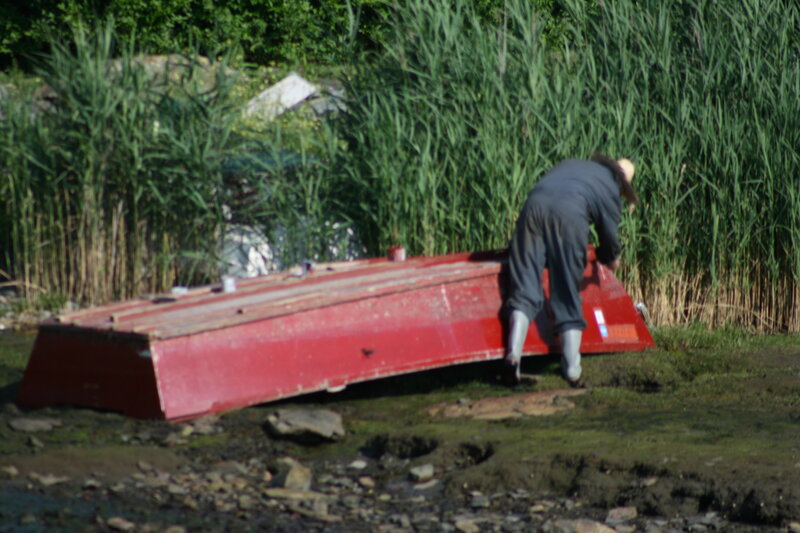 Person with red boat on shore