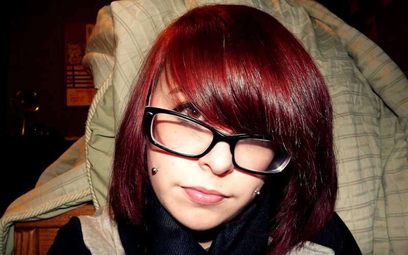 person with red hair and glasses