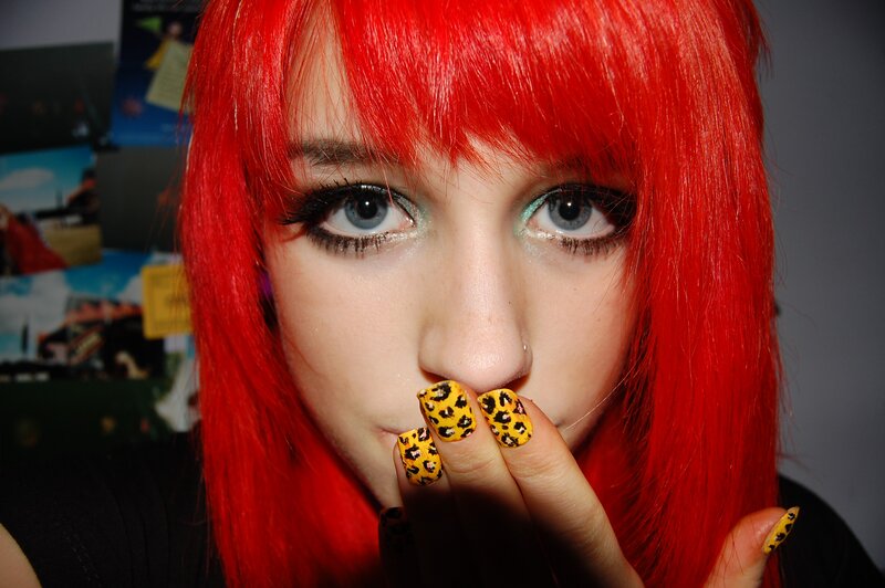 person with red hair and leopard nails