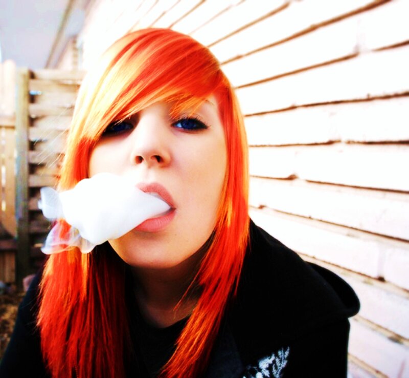 person with red hair blowing bubble