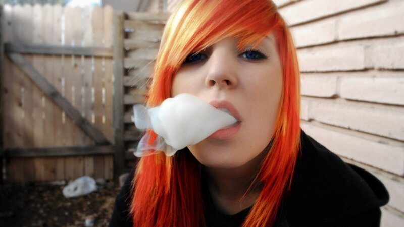 person with red hair blowing bubble gum