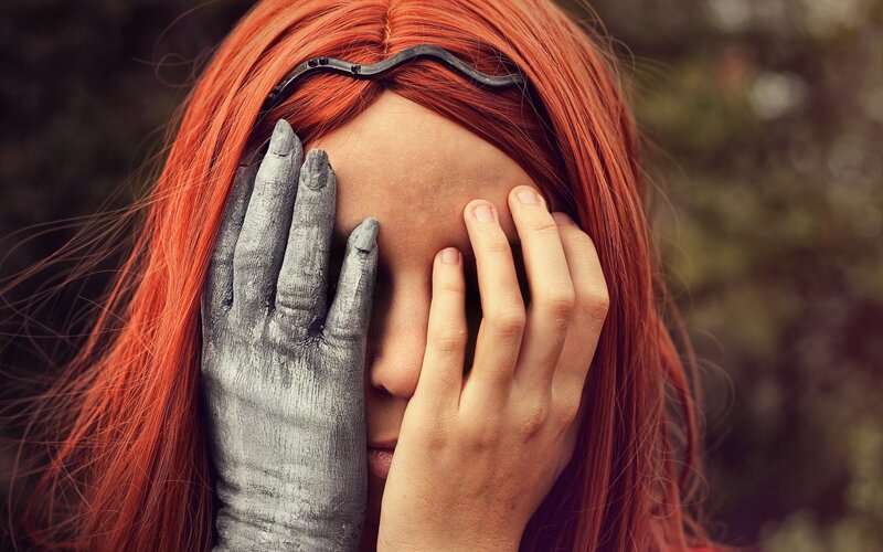 person with red hair covering face