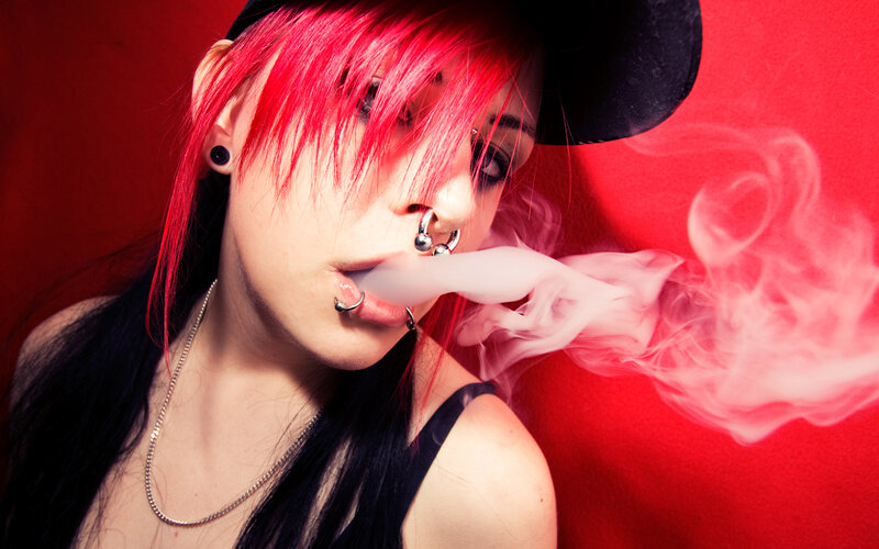person with red hair exhaling smoke