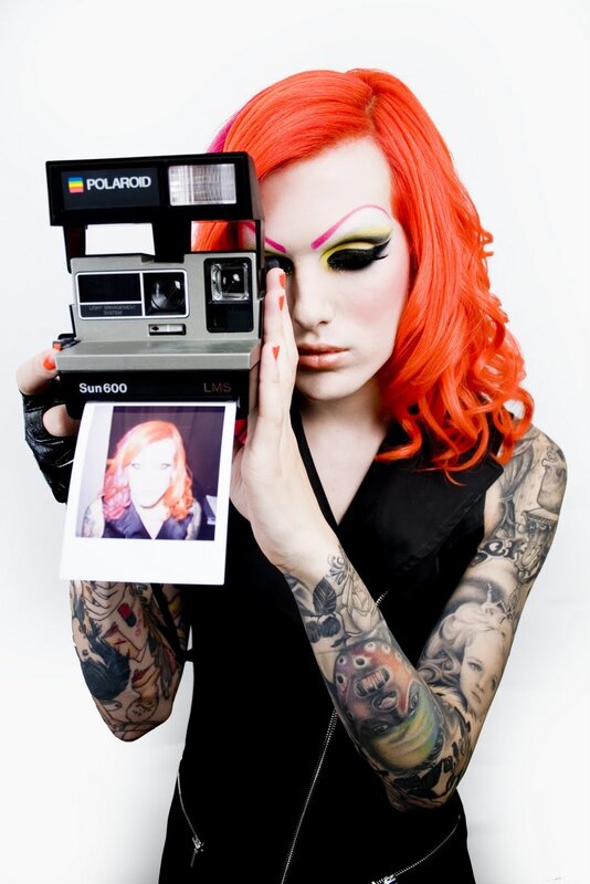 person with red hair holding polaroid
