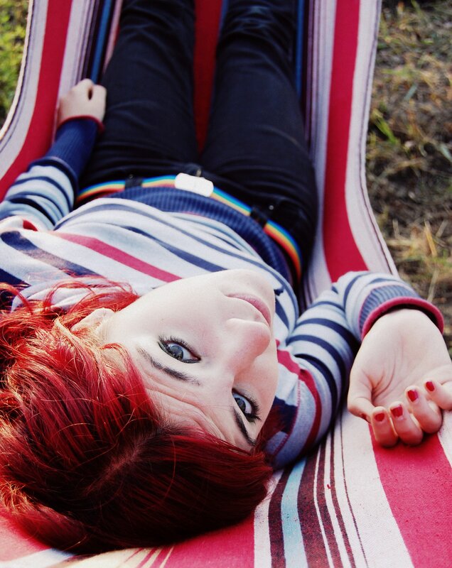 Person with red hair in a hammock