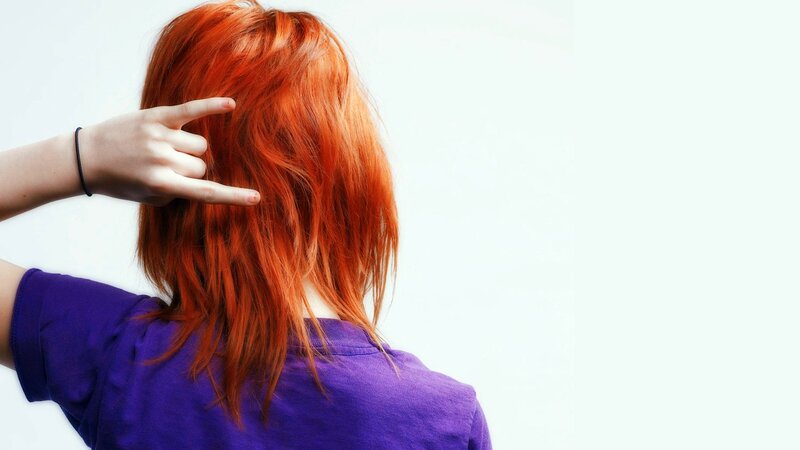 person with red hair making hand gesture