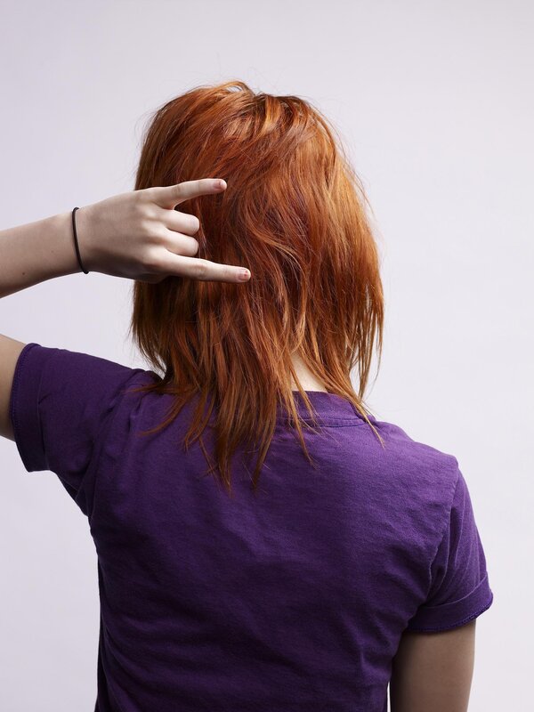 person with red hair making hand gesture