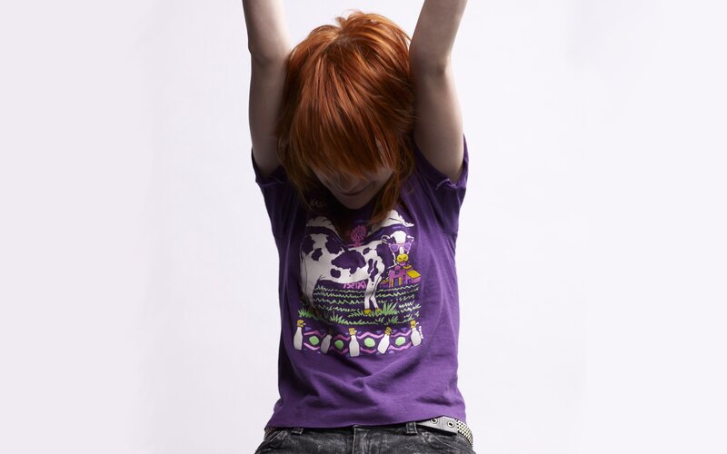 person with red hair raising arms