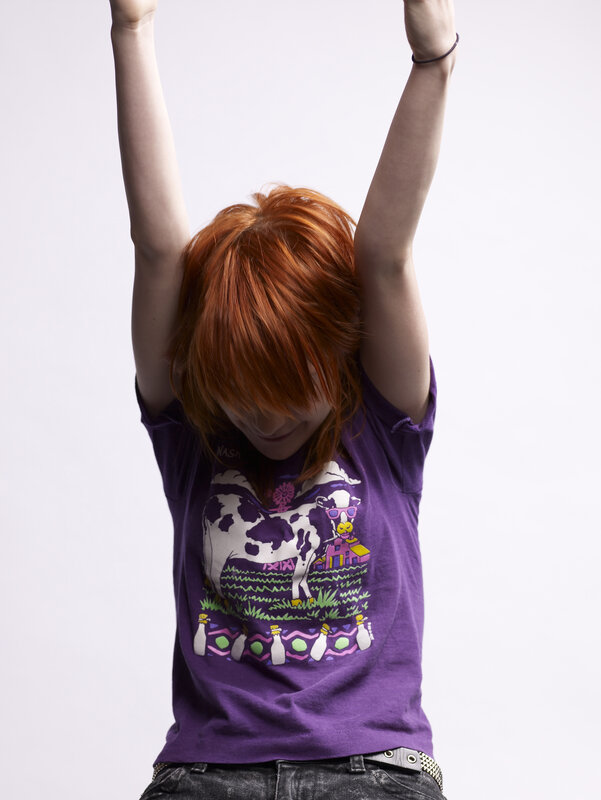person with red hair raising arms