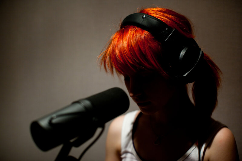 person with red hair recording audio