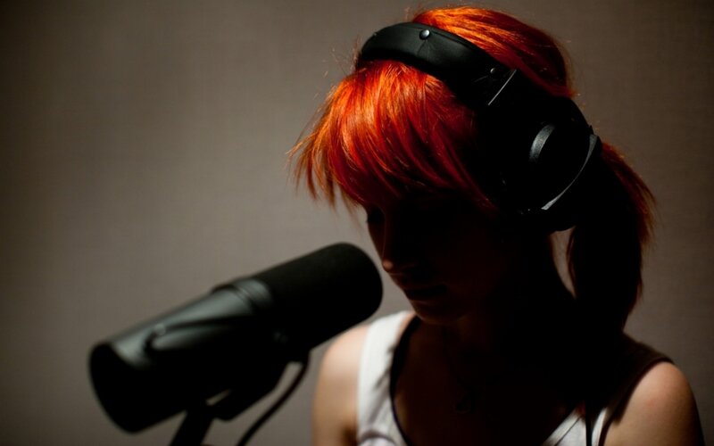 person with red hair recording audio