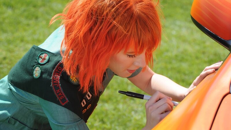 person with red hair signing car