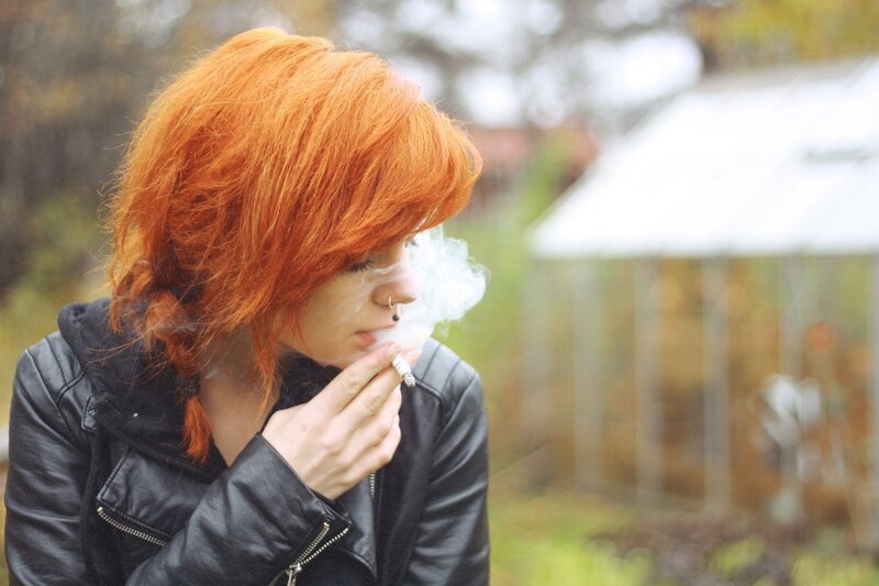 person with red hair smoking