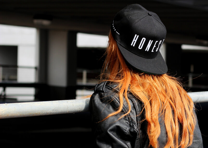person with red hair wearing cap