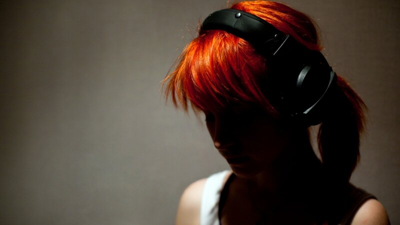person with red hair wearing headphones