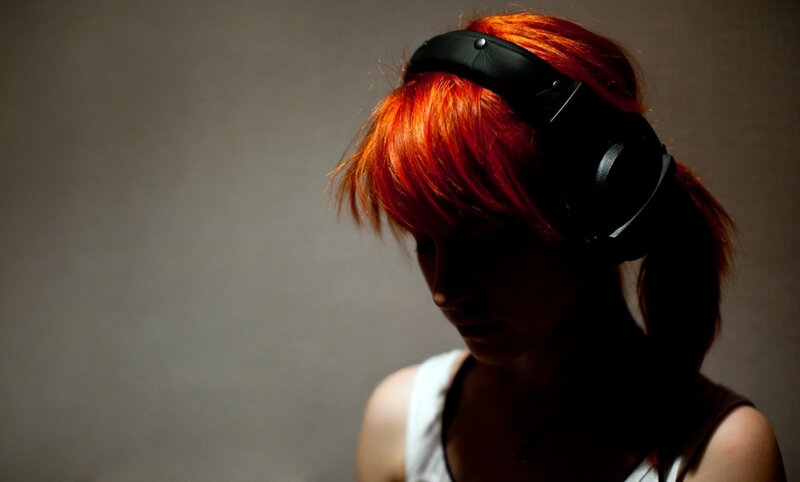 person with red hair wearing headphones