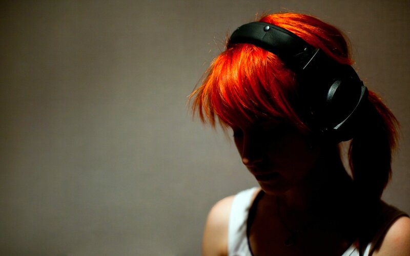 person with red hair wearing headphones
