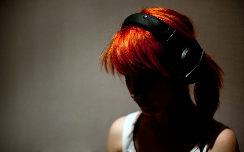 person with red hair wearing headphones