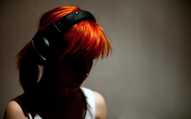 person with red hair wearing headphones