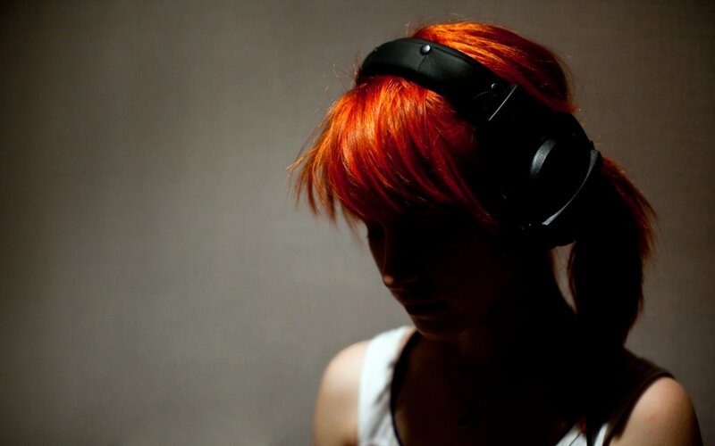person with red hair wearing headphones
