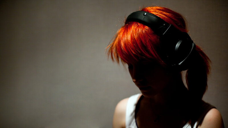person with red hair wearing headphones