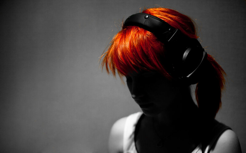 person with red hair wearing headphones