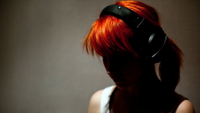 person with red hair wearing headphones
