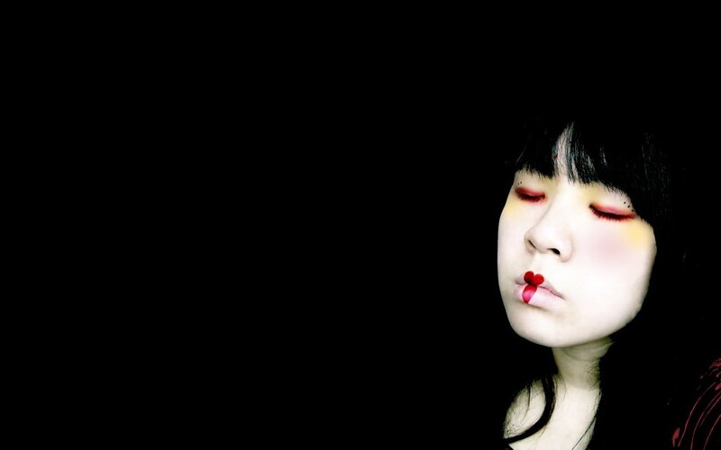 person with red makeup and closed eyes