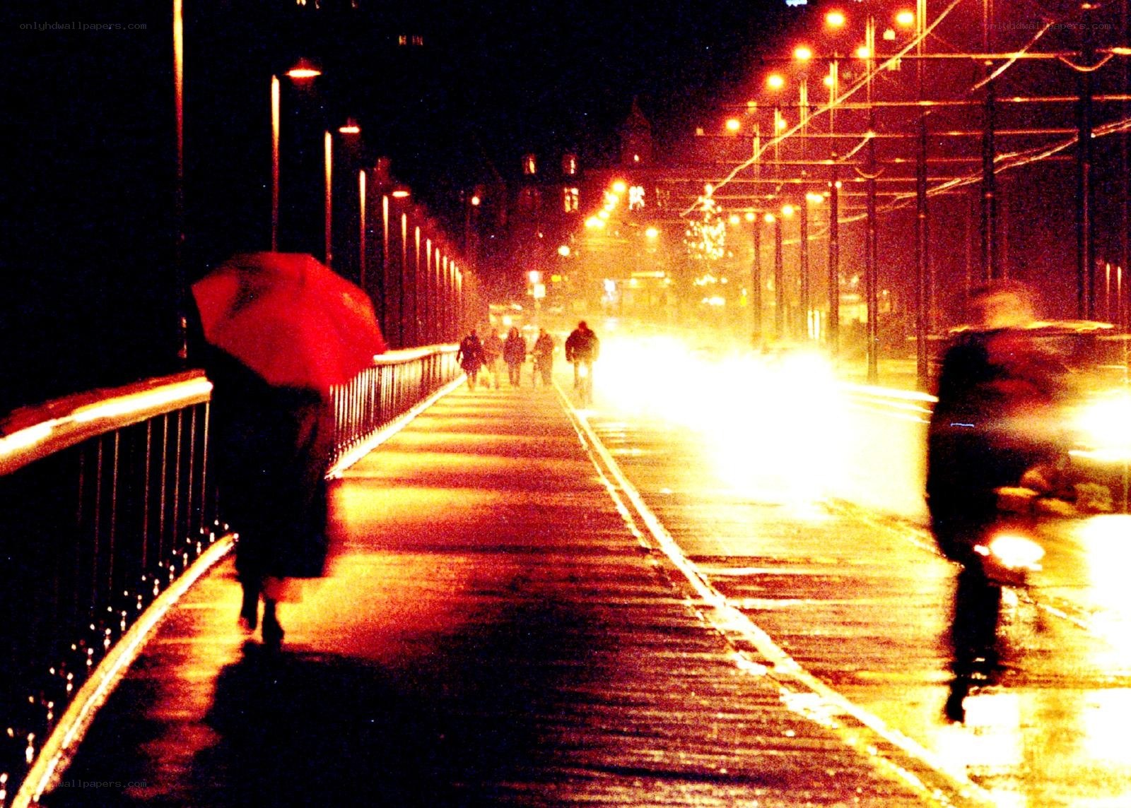 Person with red umbrella on bridge