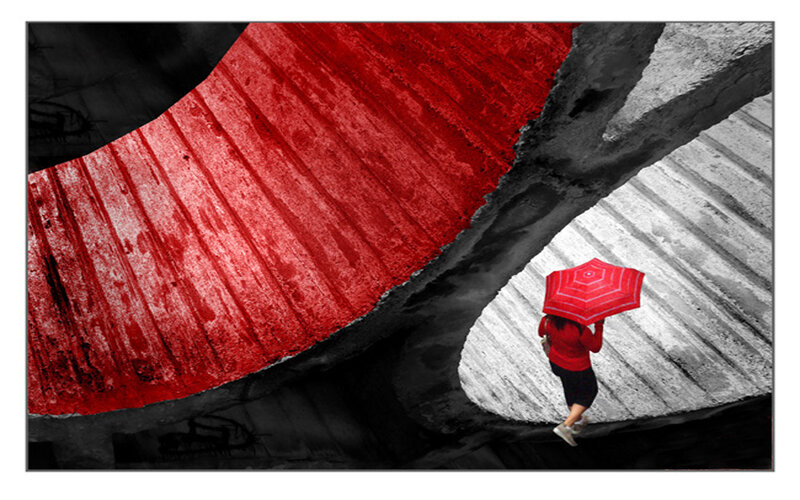 Person with red umbrella under bridge