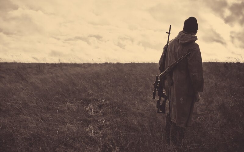 person with rifle in field
