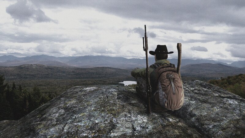 Person with Rifle on Rock