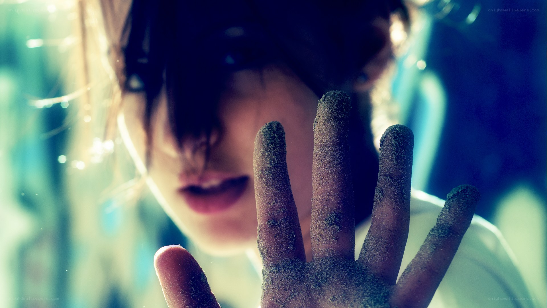 person with sand-covered hand
