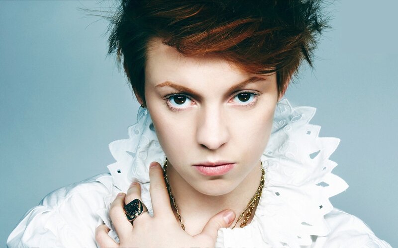 person with short hair and white ruffled collar