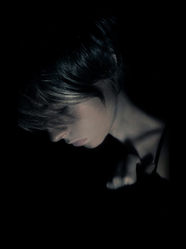 person with short hair in darkness