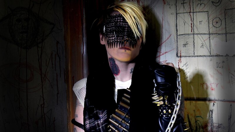 person with spiked mask and tattoos
